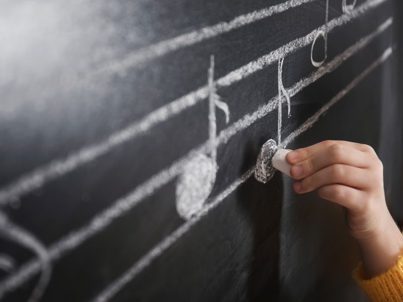 Photo of Danton adjusting music notes for a student at one of his in-home lessons.